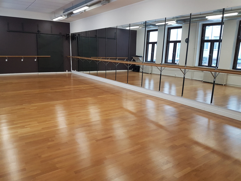 Annankadun avara ja kiiltävän puhdas sali. Salia kiertää balettitangot. Isot, mustakehyksiset ikkunat tuovat tilaan kauniisti valoa.