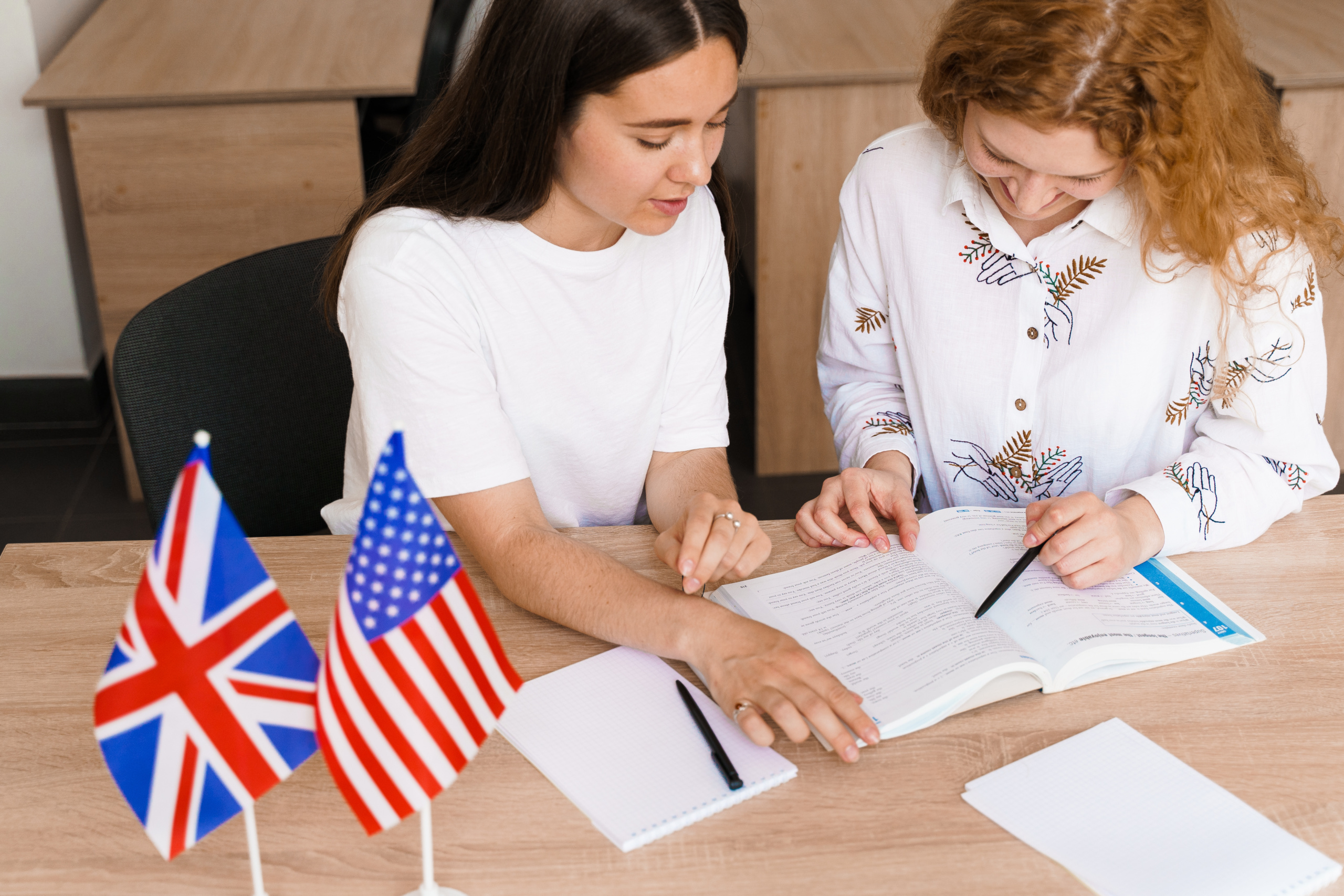 Kaksi nuorta naista opiskelee yhdessä englantia luokkahuoneessa. Helsingin aikuisopiston englannin kielen kurssit ovat nappivalinta jokaiselle, joka haluaa kehittyä. 